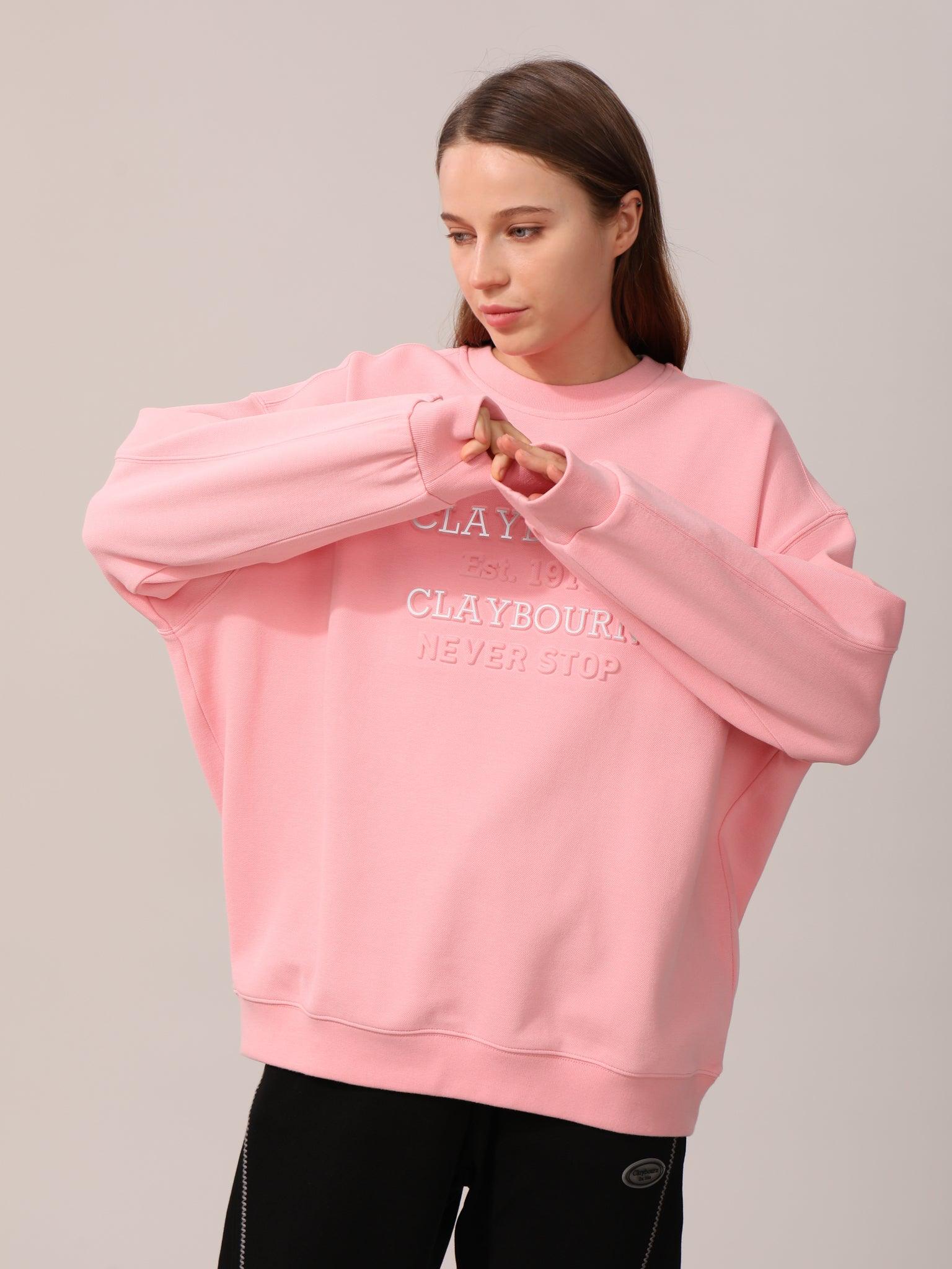 Picture of a woman wearing pink sweater with Claybourn design.