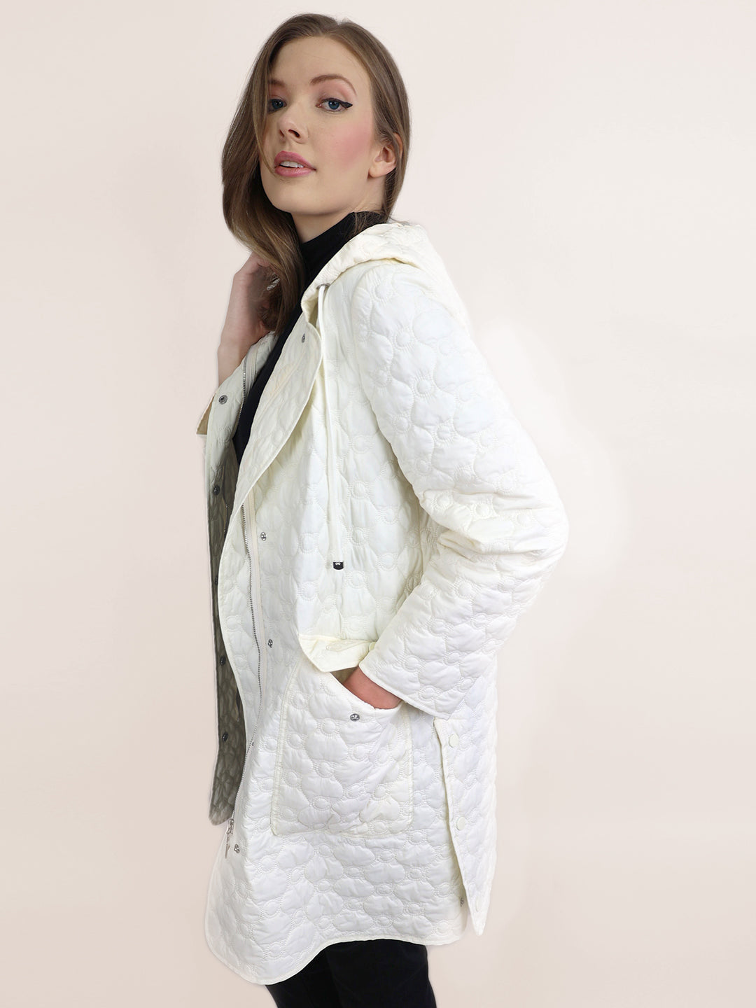 A picture of a woman with long hair posing in white coat.