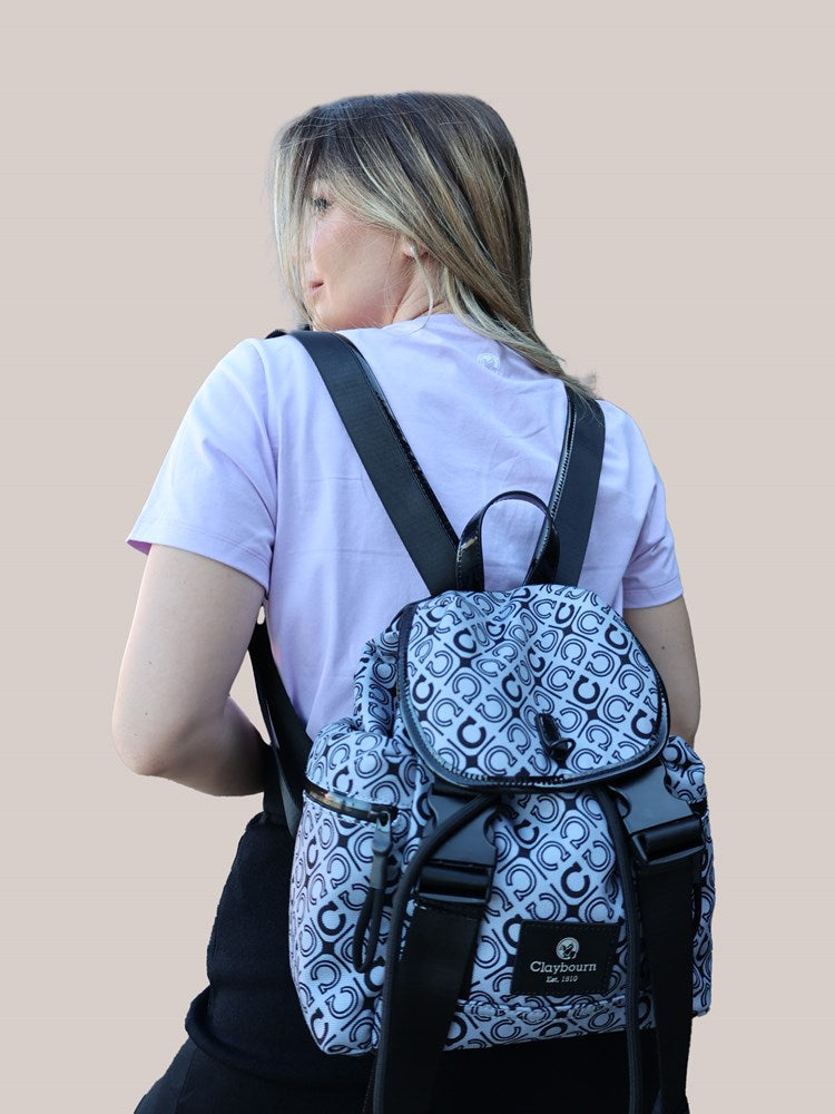 Picture of a woman facing back, wearing a white shirt and a bag.